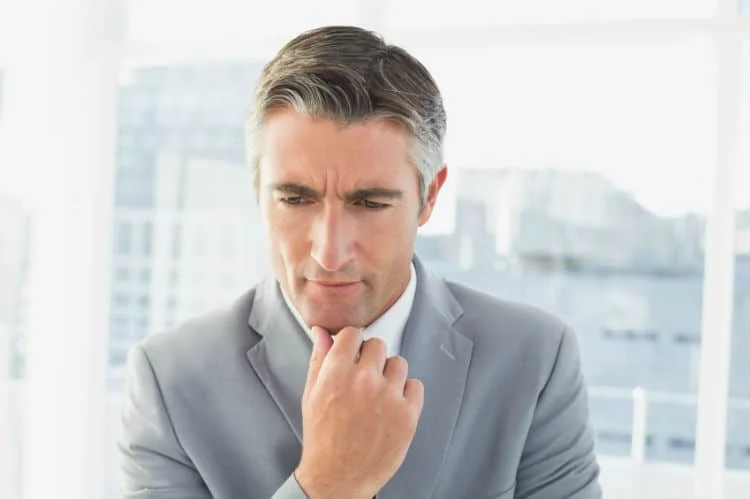 Man in a gray suit looking contemplative