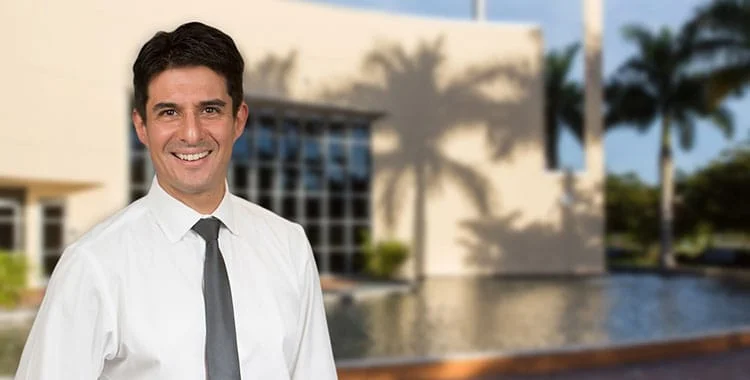Professional portrait of Dr. Miranda-Sousa in a modern, tropical outdoor setting – experienced urologist at Urology Experts.